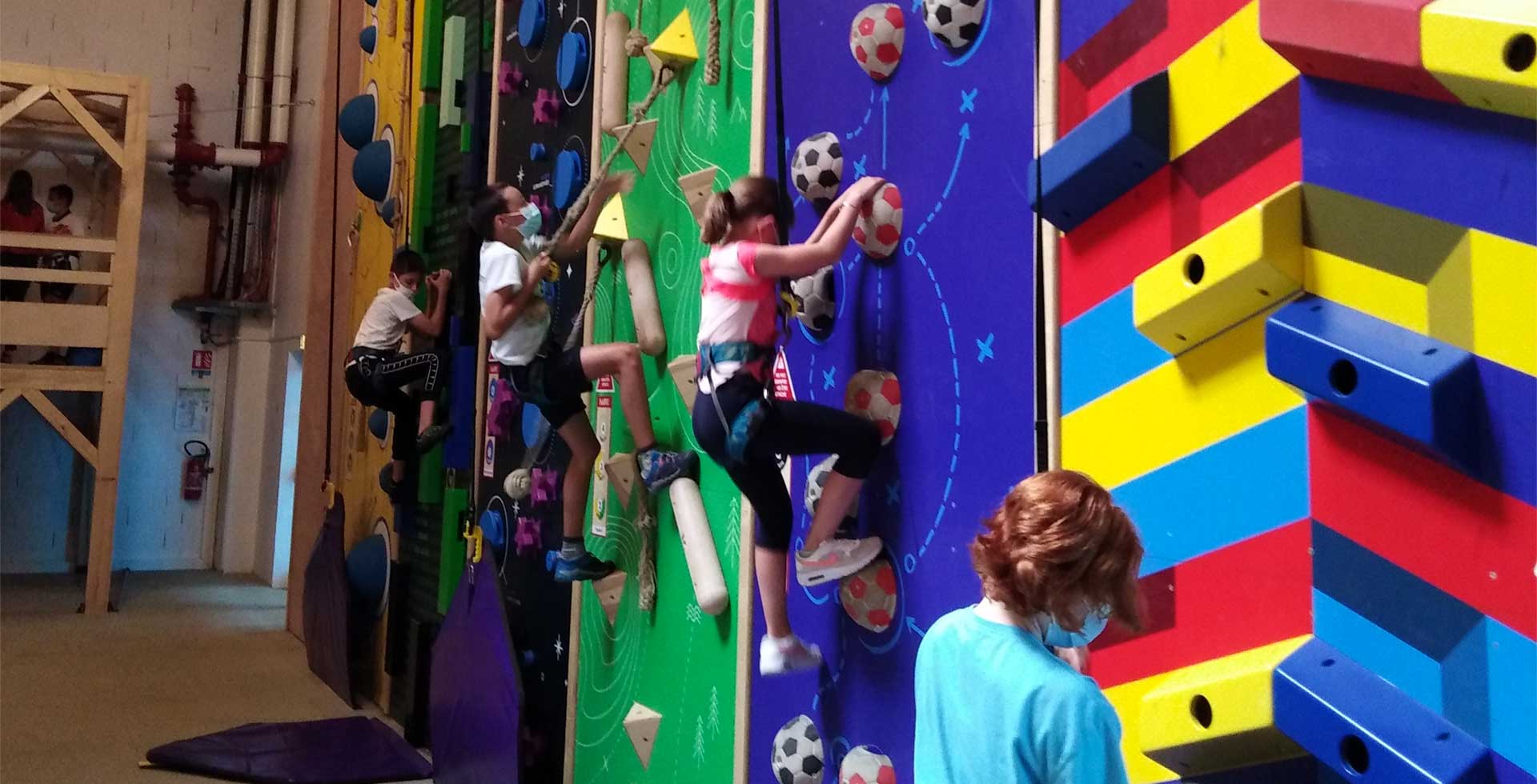 Enfants qui font de l'escalade sur un mur d'escalade