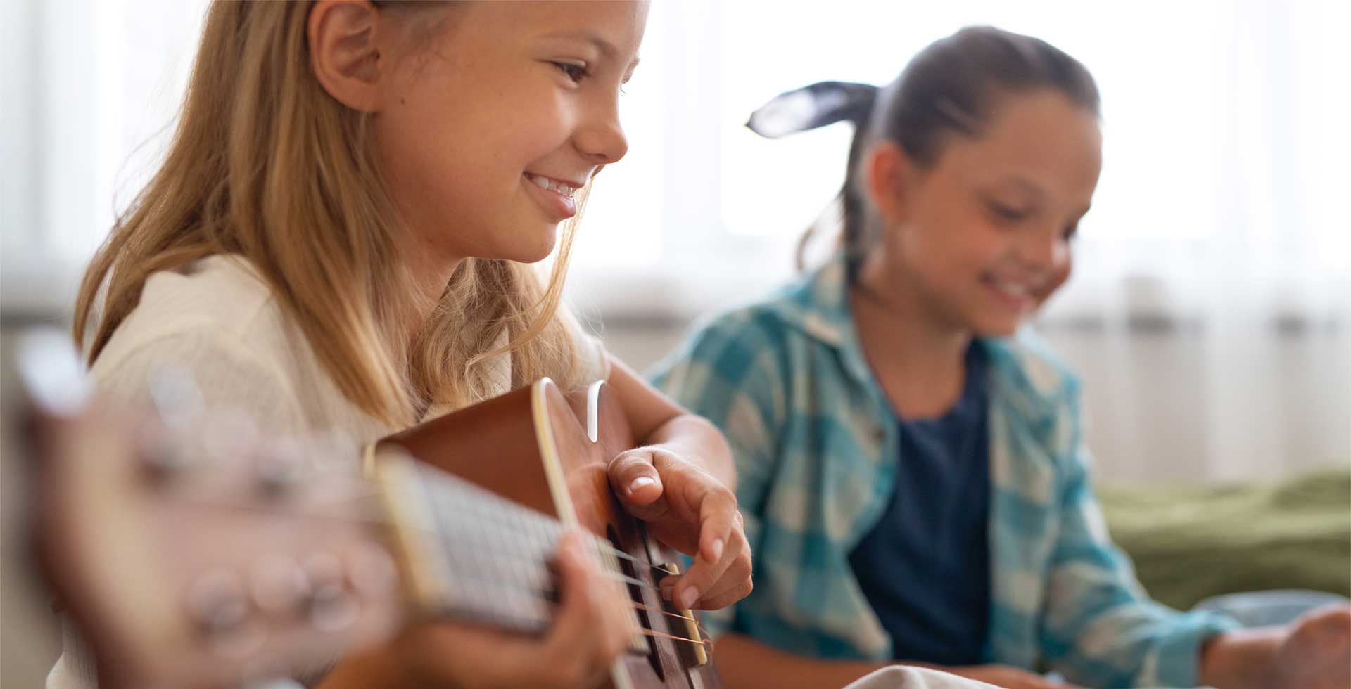 Jeune fille qui joue de la guitare à côté d'une copine