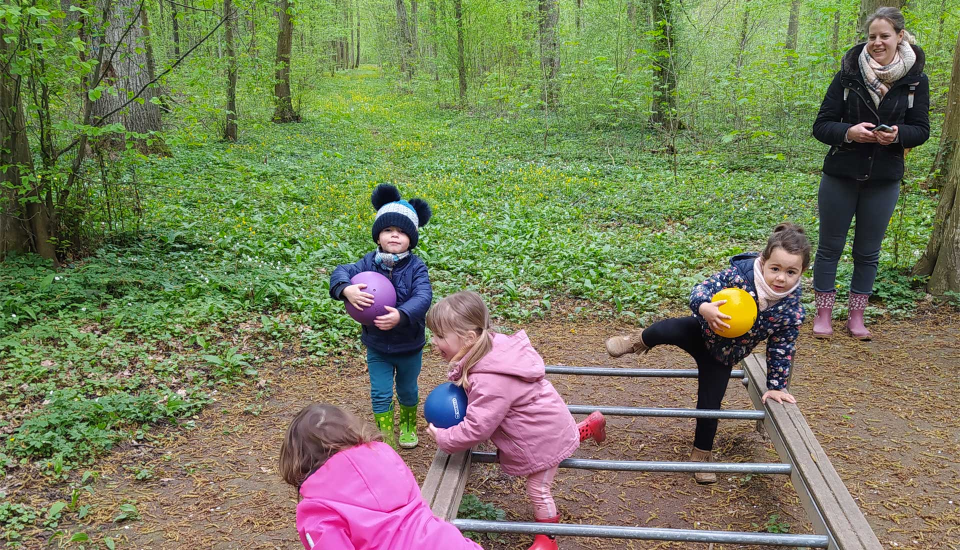 Enfants qui s'amusent en forêt sous la surveillance d'une animatrice