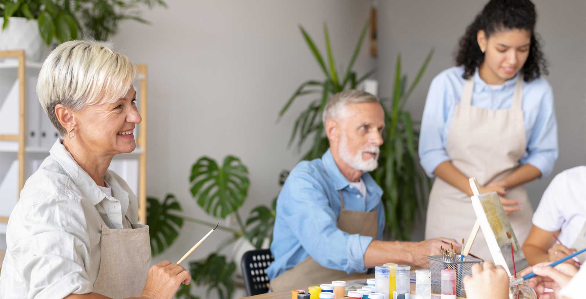 Seniors souriants en atelier peinture