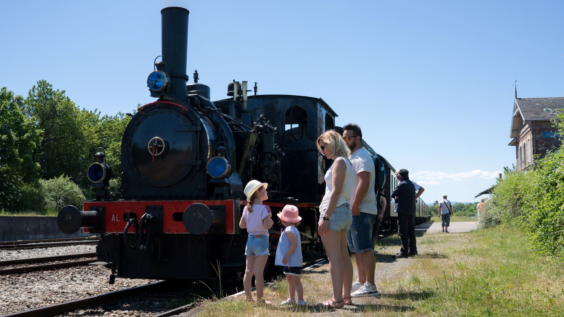 Chemin de fer touristique avec famille devant avant de monter dans le train.