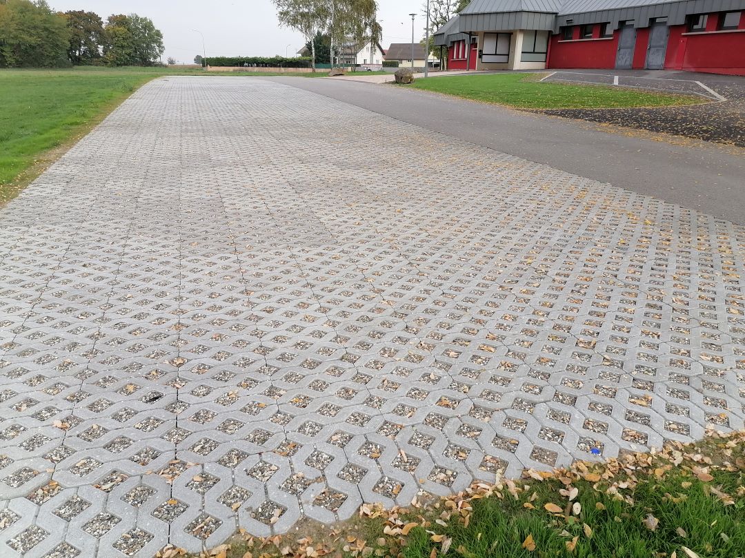 aménagement parking avec sol alvéole pour faciliter l'écoulement de l'eau de pluie.