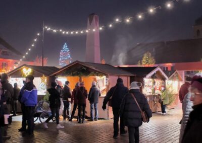 Marché de Noel exposants et chalands en soirée