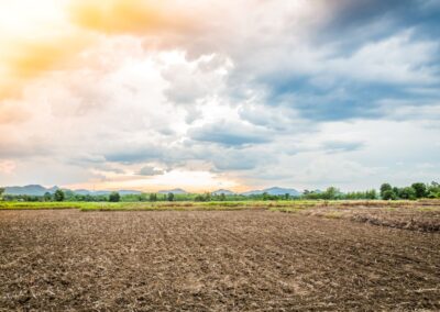 Champ labouré avec rayon de soleil traversant un ciel nuageux