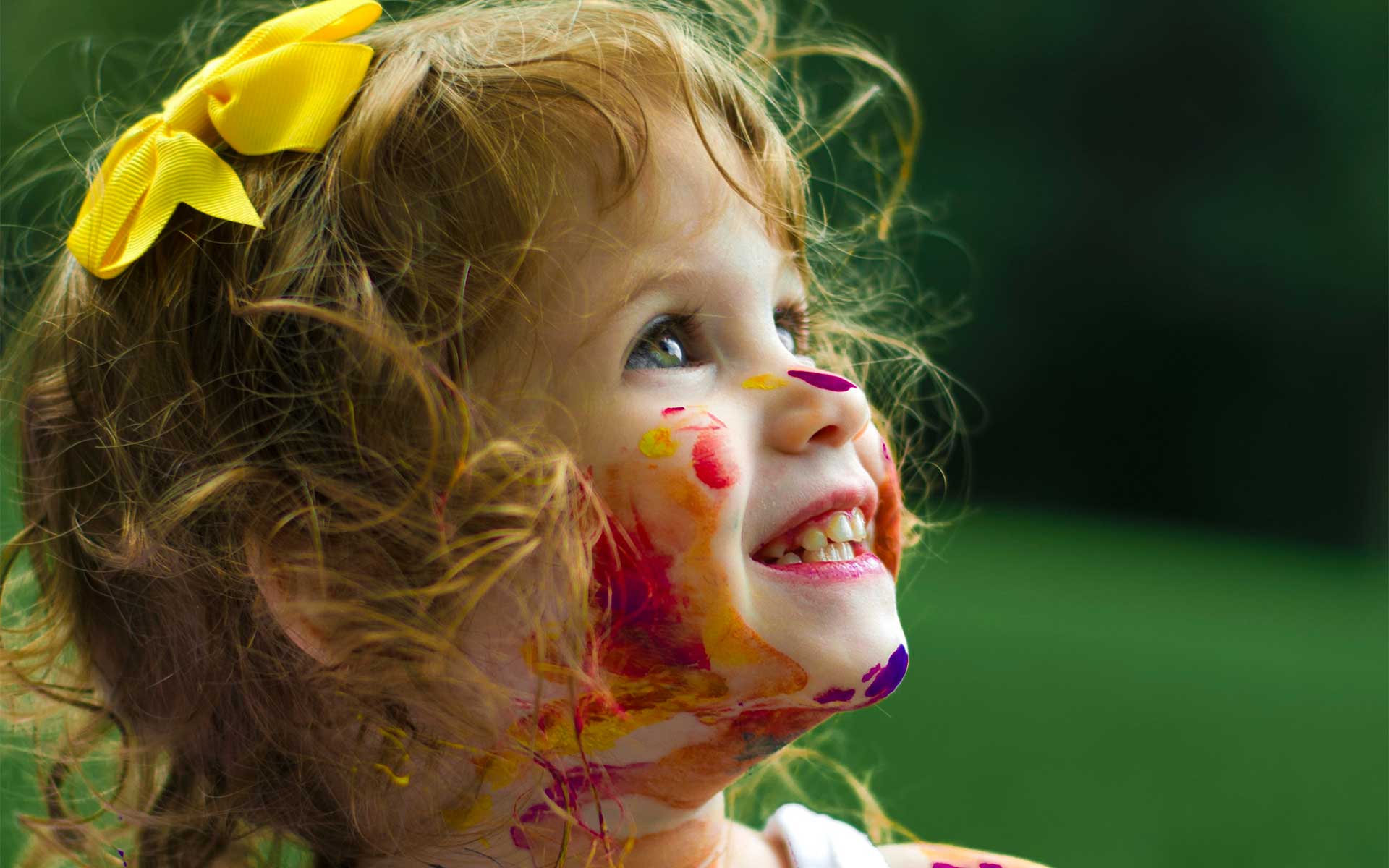 Petite fille souriante avec le visage taché de peinture