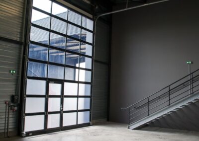 intérieur d'un atelier de la pépinière l'Envol avec vue donnant sur la porte de garage