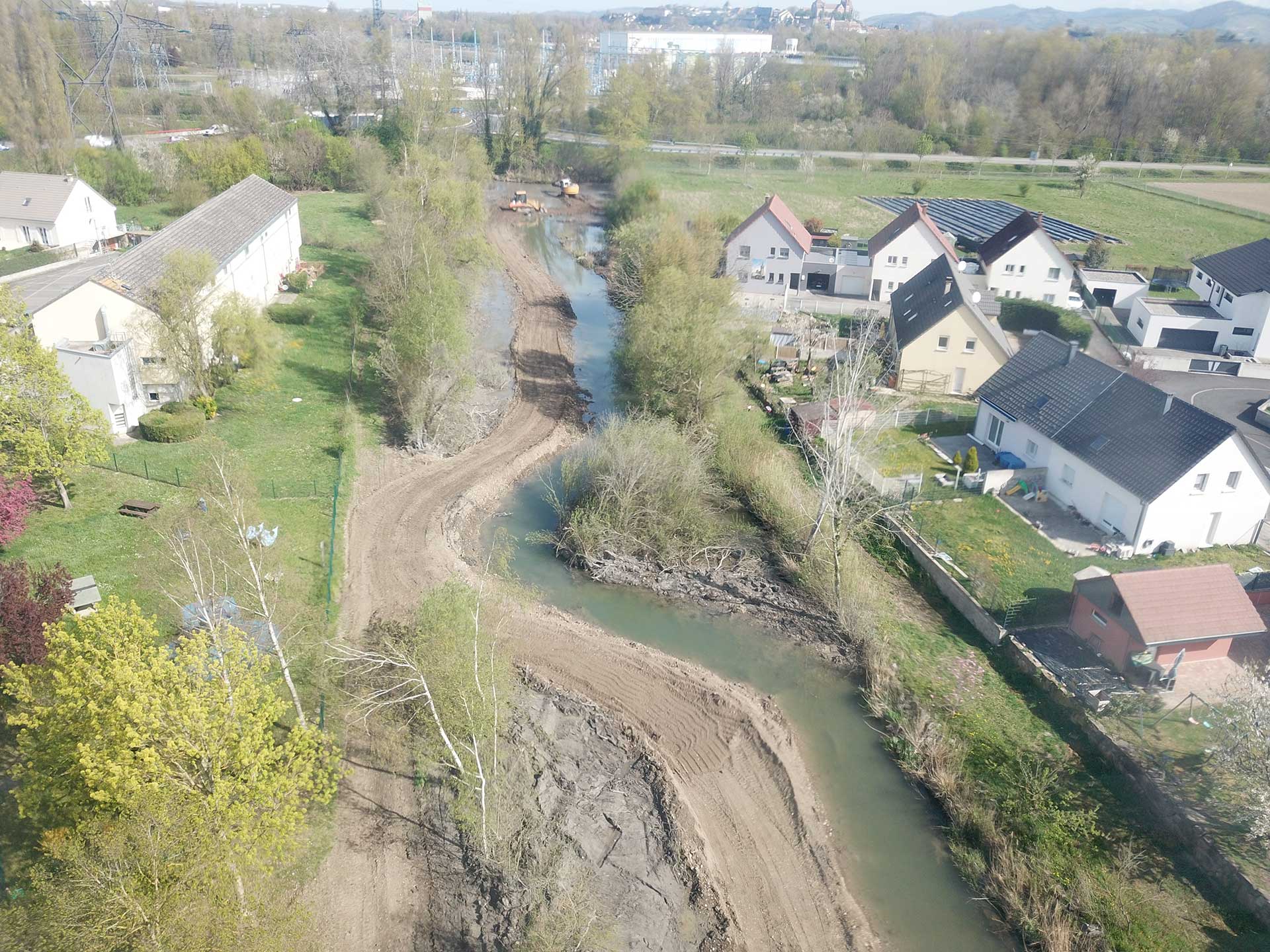 Vue du ciel d'un lotissement avec des habitations sur les 2 côtés de la rive d'un fleuve