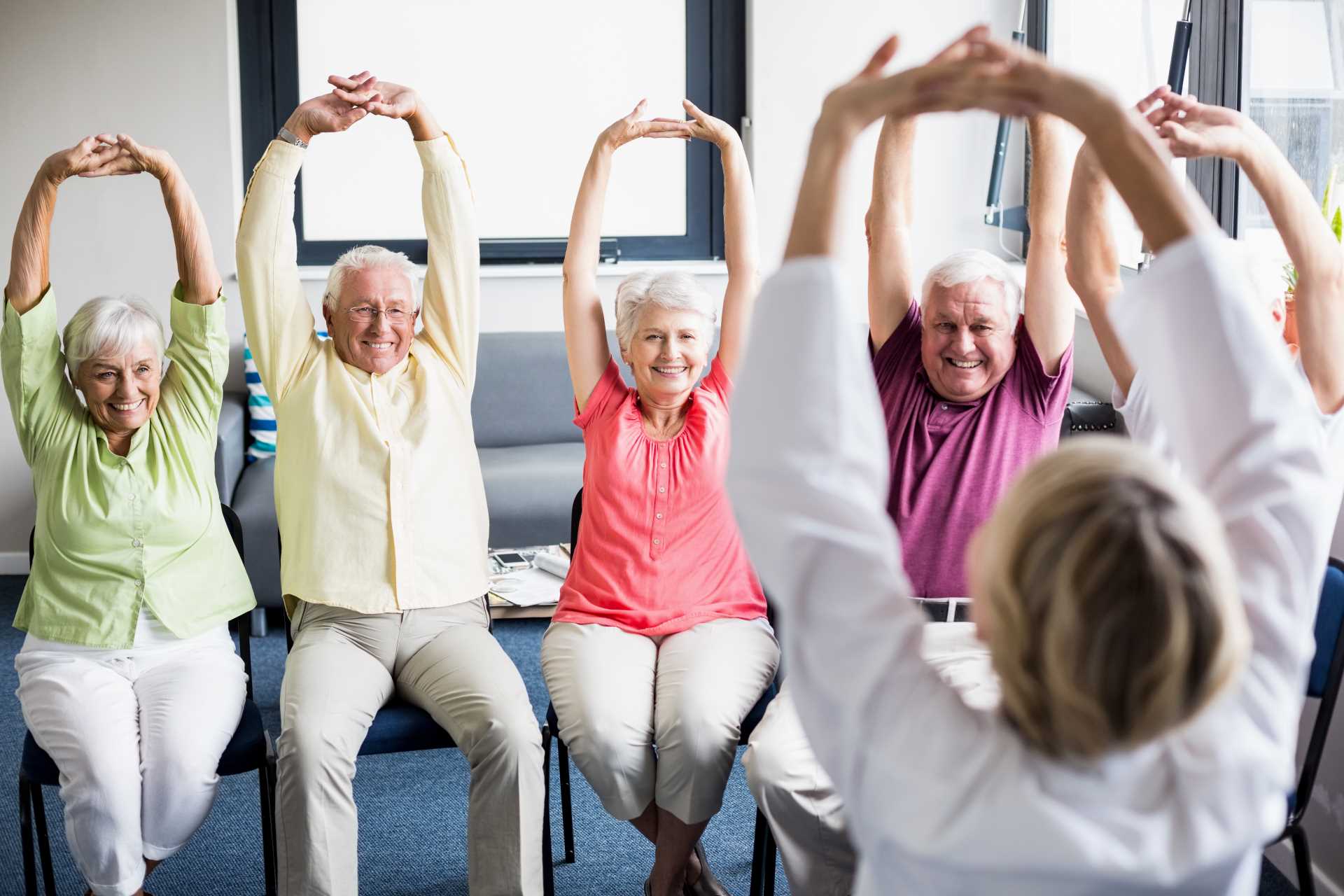 Personnes âgées assises entrain d de faire de l'exercice