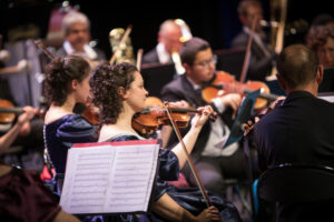 photo d'un orchestre avec plusieurs musiciens sur scène