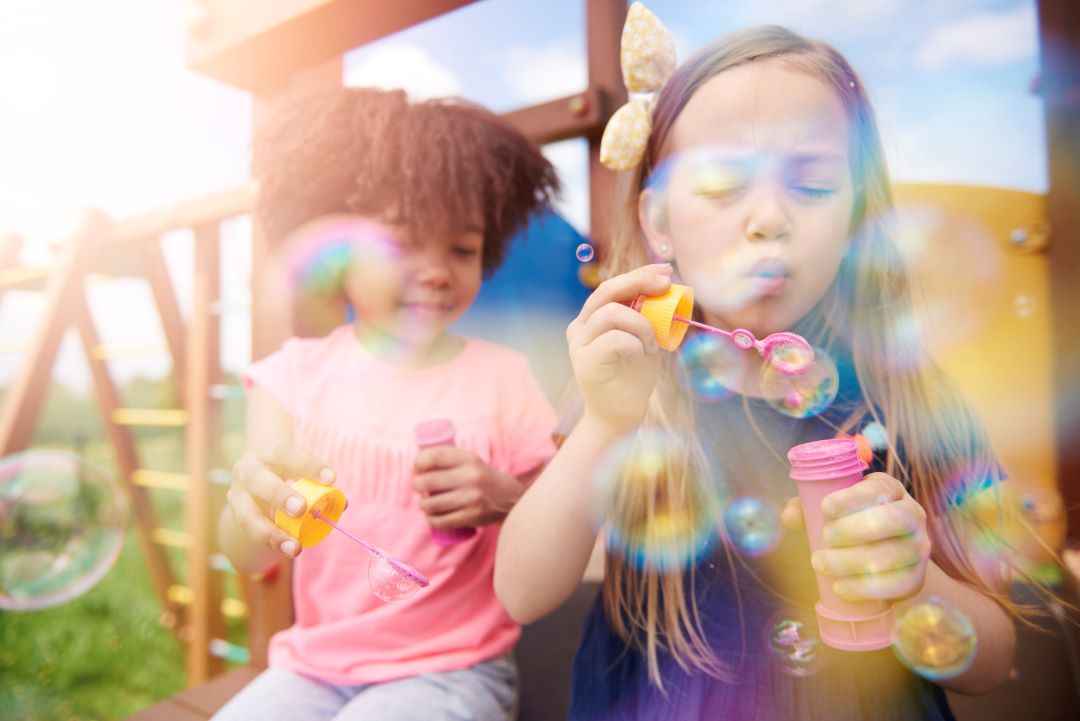 deux jeunes filles, blonde et métissé, envoie des bulles de savon